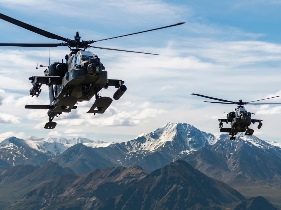 AH-64D Apache Longbow attack helicopters fly over a mountain range near Fort Wainwright, Alaska, on June 3, 2019.