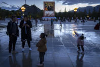 Tourists stand near a large mural depicting Chinese President Xi Jinping on a square near the Potala Palace in Lhasa in western China's Tibet Autonomous Region, Tuesday, June 1, 2021. Tourism is booming in Tibet as more Chinese travel in-country because of the coronavirus pandemic, posing risks to the region's fragile environment and historic sites. (AP Photo/Mark Schiefelbein)