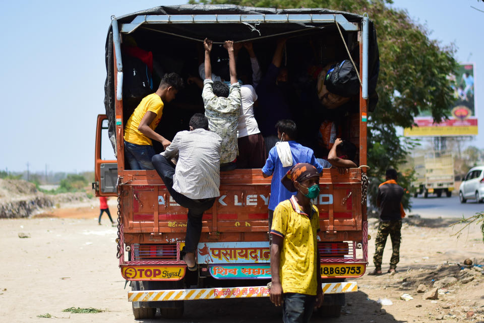 MUMBAI, MAHARASHTRA, INDIA - 2020/05/13: People getting onto a truck during the lockdown. Due to lockdown situation, most migrants are stuck in Mumbai, some walk and others arrange their own trucks and buses to their home towns, while the police say that the buses are available by the government. (Photo by Ratika More/SOPA Images/LightRocket via Getty Images)