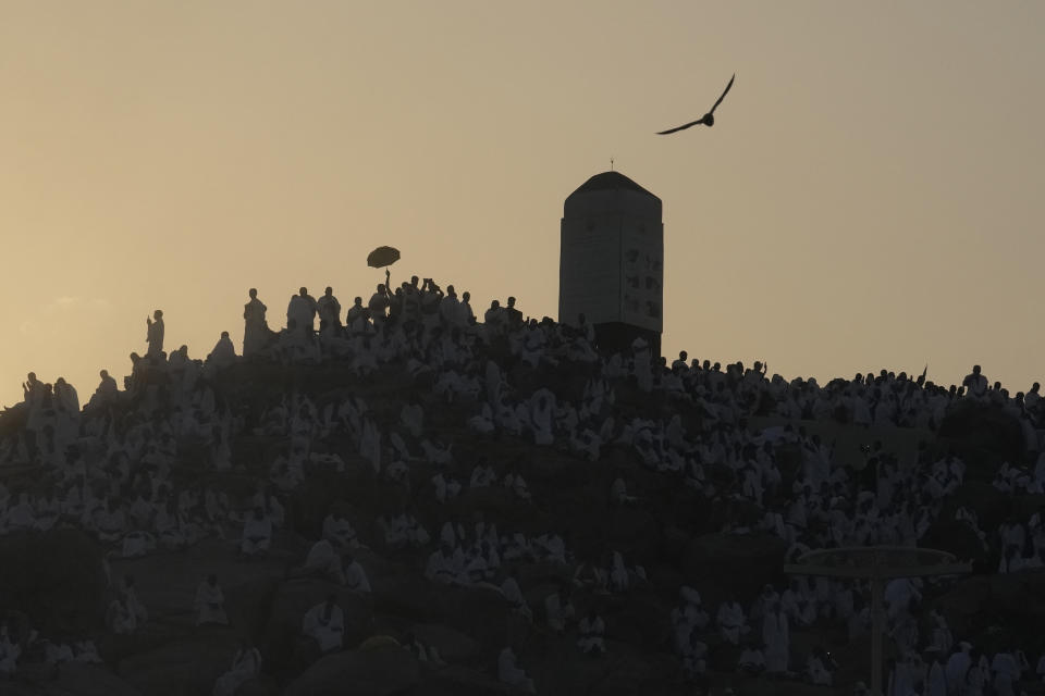 Muslim pilgrims prayers at top of the rocky hill known as the Mountain of Mercy, on the Plain of Arafat, during the annual Hajj pilgrimage, near the holy city of Mecca, Saudi Arabia, Saturday, June 15, 2024. Masses of Muslims gathered at the sacred hill of Mount Arafat in Saudi Arabia for worship and reflection on the second day of the Hajj pilgrimage. The ritual at Mount Arafat, known as the hill of mercy, is considered the peak of the Hajj. It's often the most memorable event for pilgrims, who stand shoulder to shoulder, asking God for mercy, blessings, prosperity and good health. Hajj is one of the largest religious gatherings on earth.(AP Photo/Rafiq Maqbool)