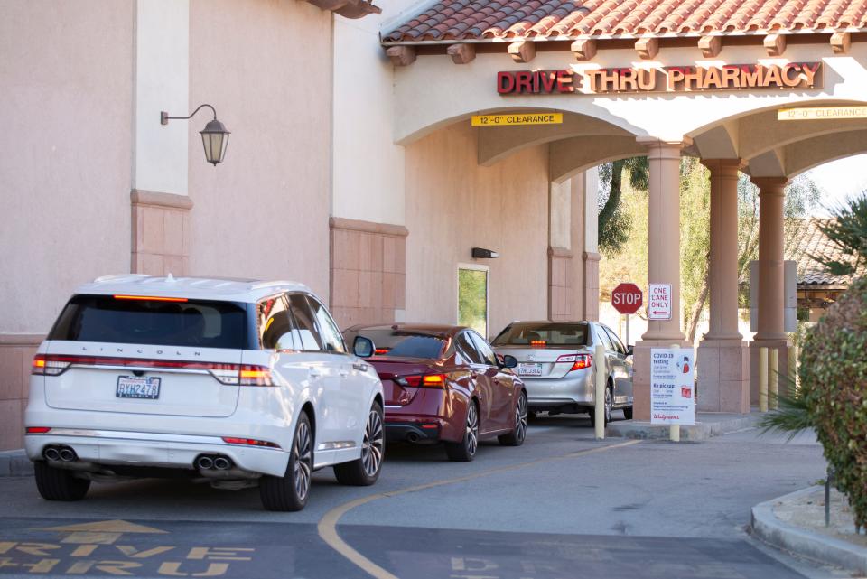 Vehicles line up in a drive-thru lane offering COVID testing at Walgreens on Washington Street in La Quinta, California, on Sunday, Jan. 2, 2022.