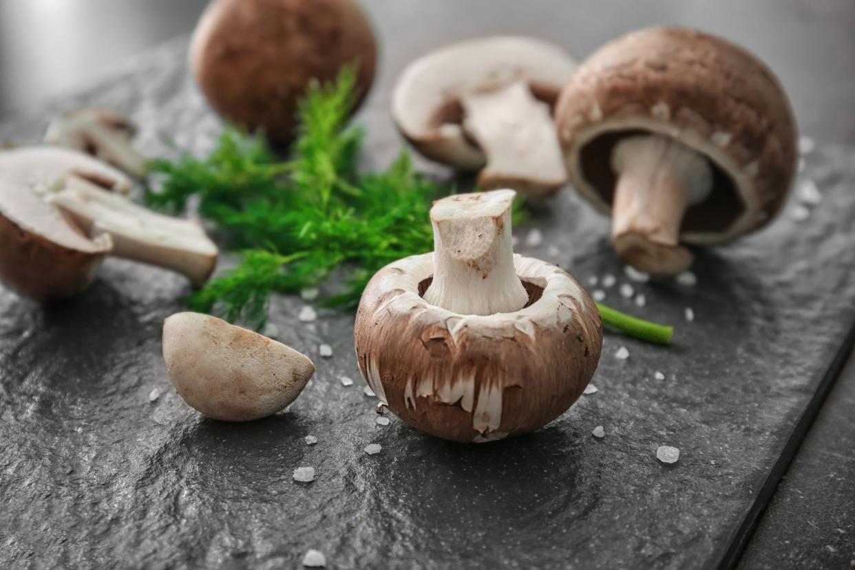 Slate plate with cremini mushrooms on table