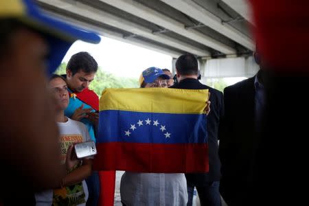 A Venezuelan woman listens to the Venezuelan opposition lawmakers (not pictured), as they talk to a small group of Venezuelan protesters outside the site where the Organization of American States (OAS) 47th General Assembly is taking place in Cancun, Mexico June 21, 2017. REUTERS/Carlos Jasso