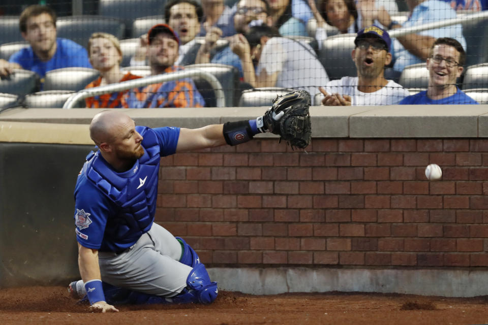 Chicago Cubs' catcher Jonathan Lucroy slides into the wall behind home plate as he tries catch to catch New York Mets' Pete Alonso's pop fly during the first inning of a baseball game Thursday, Aug. 29, 2019, in New York. (AP Photo/Kathy Willens)