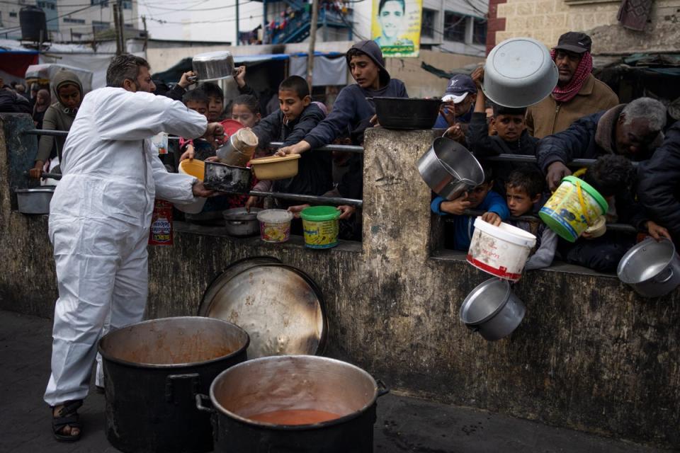 Palestinians line up for free food in Rafah, Gaza Strip, amid warnings of famine across the region (AP)