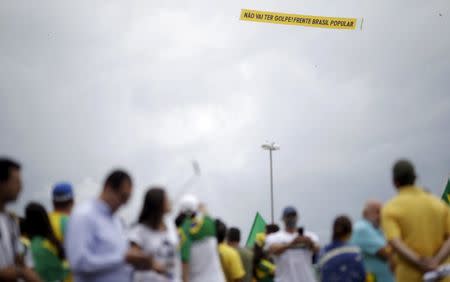 Demonstrators are pictured near a banner that reads, "There will be no coup! Popular Front Brazil" as they attend a protest against Brazil's President Dilma Rousseff, part of nationwide protests calling for her impeachment, at Copacabana beach in Rio de Janeiro, Brazil, March 13, 2016. REUTERS/Ricardo Moraes