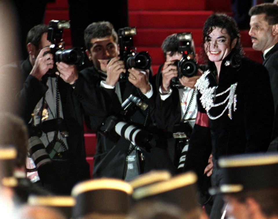 Photographers surround Michael Jackson as he arrives for the midnight screening of his movie short ‘Ghosts’ at the 50th Cannes on 8 May 1997 (Reuters)