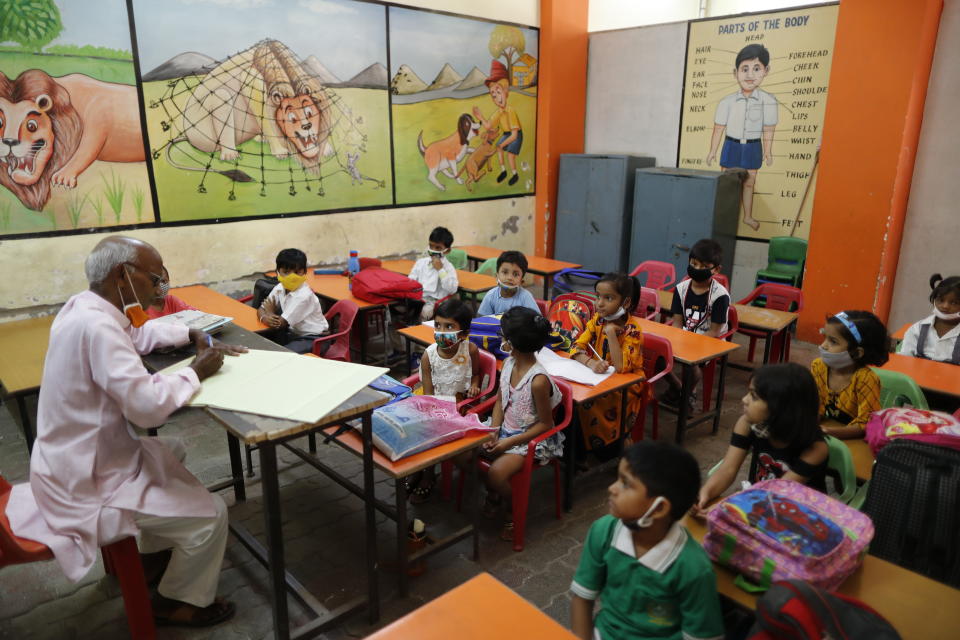 Students attend a class on the first day of partial reopening of schools in Prayagraj, India, Wednesday, Sept. 1, 2021. More students in India will be able to step inside a classroom for the first time in nearly 18 months Wednesday, as authorities have given the green light to partially reopen more schools despite apprehension from some parents and signs that infections are picking up again. Schools and colleges in at least six more states will reopen in a gradual manner with health measures in place throughout September. (AP Photo/Rajesh Kumar Singh)