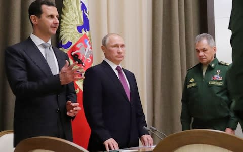 Syria's President Bashar al-Assad, Russia's President Vladimir Putin, and Russia's Defence Minister Sergei Shoigu during a meeting in Russia  - Credit: TASS