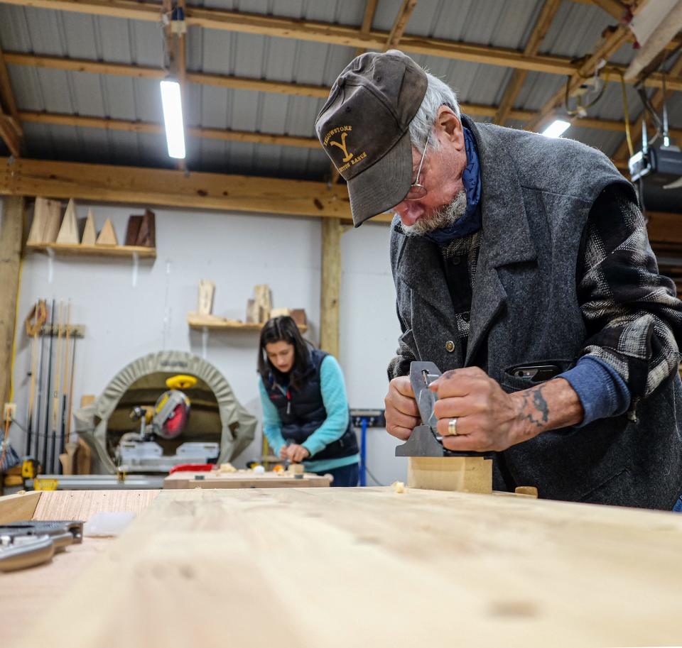 Angelo Pecora practices using a plane on a scrap piece of wood before making a picture frame at the Tiny Bit of Wood School in Holt Sunday, Nov. 21, 2021.