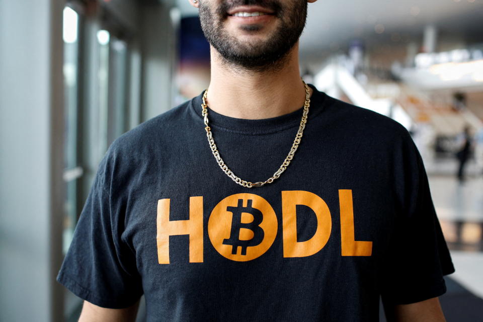 An attendee wears a t-shirt with the logo of bitcoin that reads 