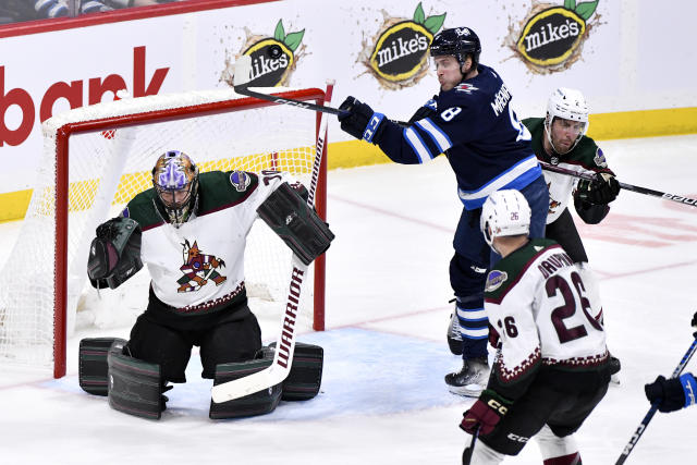 Winnipeg Jets' Saku Maenalanen (8) reaches to tip a shot in front of Arizona Coyotes goaltender Karel Vejmelka (70) during the first period of an NHL hockey game, Tuesday, March 21, 2023 in Winnipeg, Manitoba. (Fred Greenslade/The Canadian Press via AP)