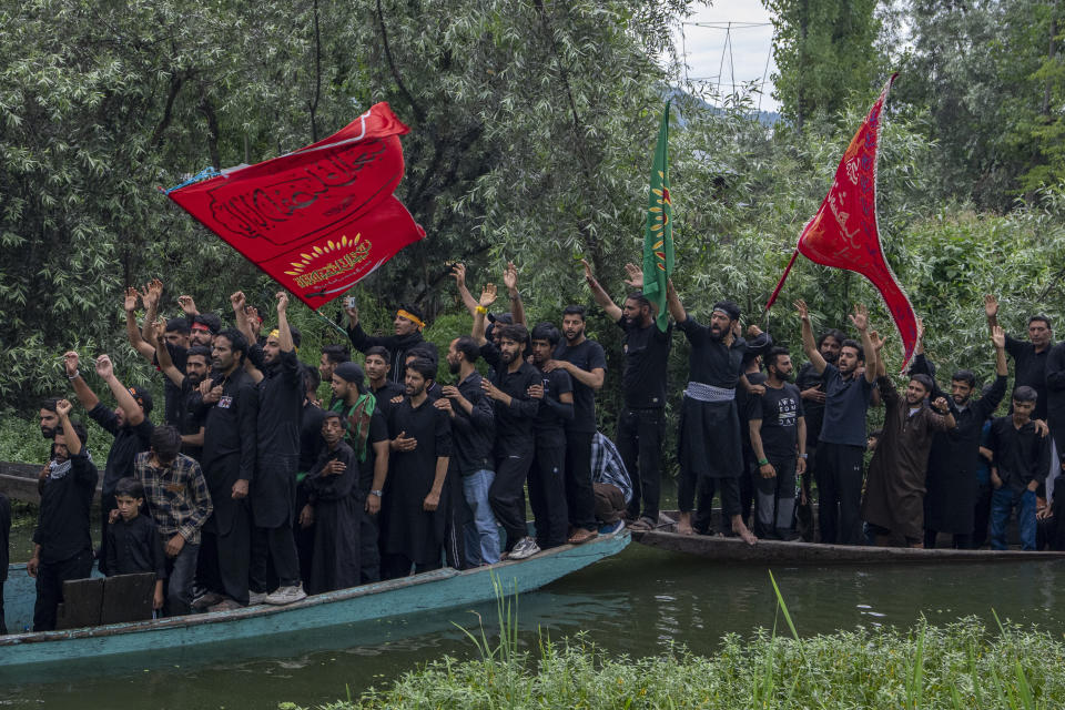 Kashmiri Shiite Muslims shout religious slogans as they participate in a Muharram procession on wooden boats in the interiors of Dal lake, on the outskirts of Srinagar, Indian controlled Kashmir, Friday, July 28, 2023. Muharram is a month of mourning in remembrance of the martyrdom of Imam Hussein, the grandson of Prophet Mohammed. (AP Photo/ Dar Yasin)