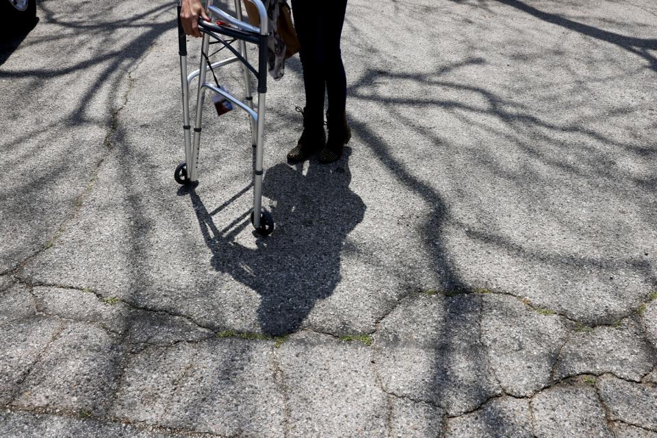 Elias walks out of the treatment center with help from her walker.