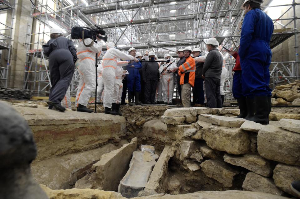 France's Culture Minister Roselyne Bachelot (C, left) visits the Notre Dame Cathedral archaeological research site after the discovery of a 14th century lead sarcophagus, in Paris, on March 15, 2022. / AFP / JULIEN DE ROSA