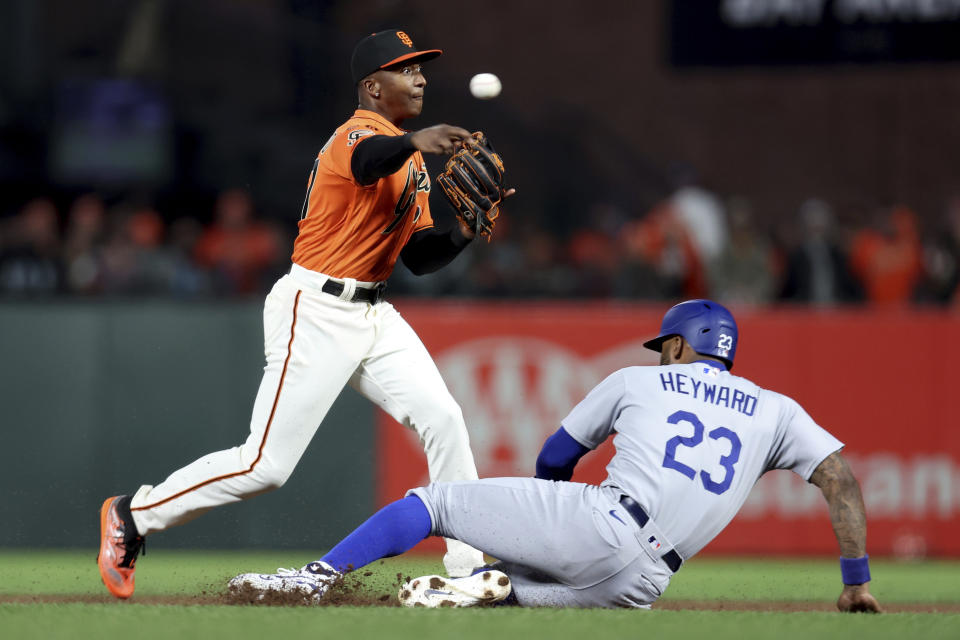 San Francisco Giants shortstop Marco Luciano throws to first as Los Angeles Dodgers' Jason Heyward (23) slides into second on a double play hit into by David Peralta during the fourth inning of a baseball game in San Francisco, Friday, Sept. 29, 2023. (AP Photo/Jed Jacobsohn)