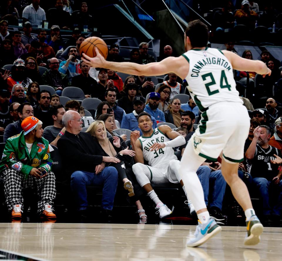 Bucks forward Giannis Antetokounmpo in the seats after saving the ball to Pat Connaughton during the first half against the Spurs on Thursday night.