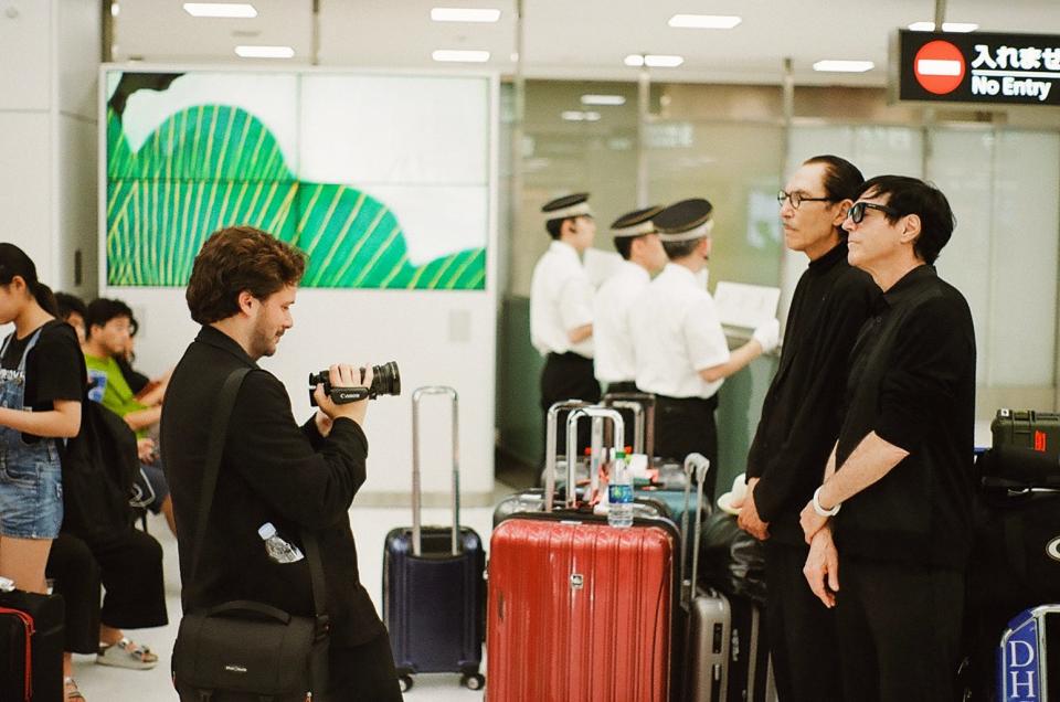 Director Edgar Wright (left) films Ron and Russell Mael in a Japanese airport during the making of "The Sparks Brothers."