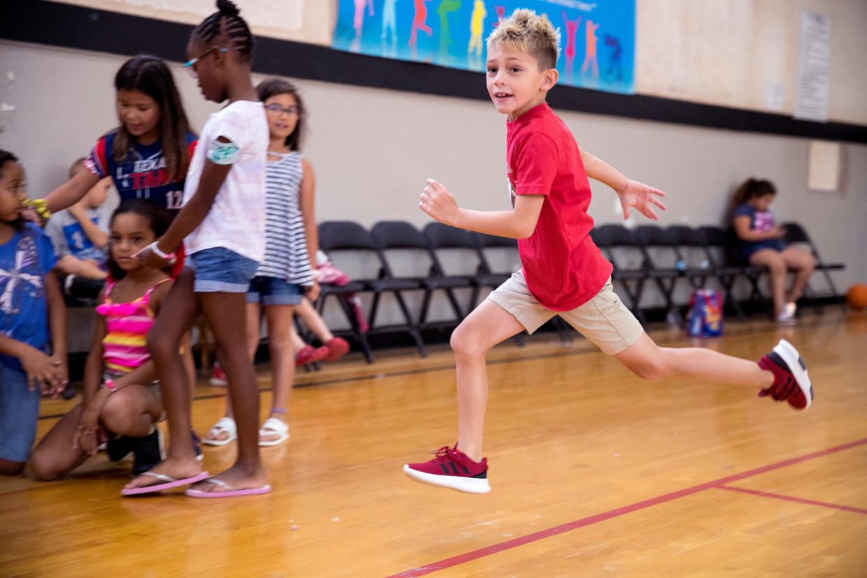 Travis Leal, 8, runs to first base while playing kickball's he attends the YMCA summer camp on Wednesday, August 14, 2019. The summer camp is popular because it is a rare summer camp that stays open until just before school starts.