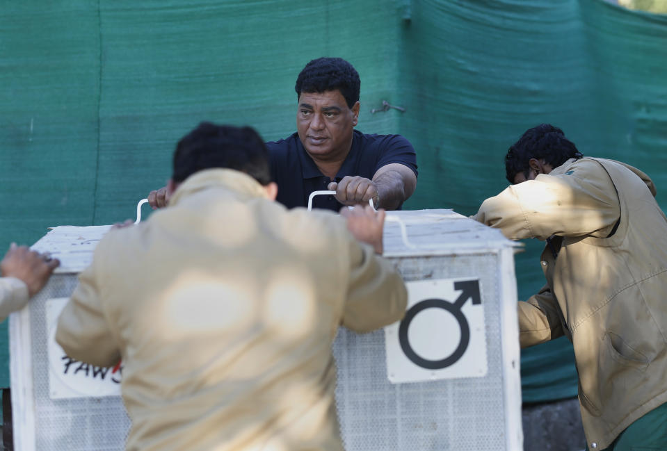 Dr. Amir Khalil, center, a veterinarian from the international animal welfare organization Four Paws, and Pakistani wildlife workers moves a crate to be used for transporting a sick brown bear, at the Marghazar Zoo, in Islamabad, Pakistan, Wednesday, Dec. 16, 2020. A pair of sick and neglected dancing Himalayan brown bears will leave Islamabad's notorious zoo Wednesday for a sanctuary in Jordan, closing down a zoo that once housed 960 animals. The Marghazar Zoo's horrific conditions gained international notoriety when Kaavan, dubbed the world's loneliest elephant, grabbed headlines and the attention of iconic American entertainer Cher. (AP Photo/Anjum Naveed)