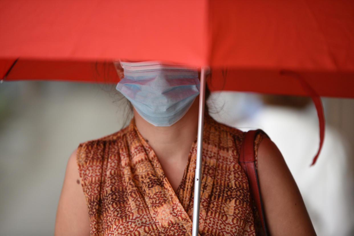 A woman carrying an umbrella as protection from the rain is seen wearing a facemask as a preventive measure against the spread of coronavirus. (Photo by Jorge Sanz / SOPA Images/Sipa USA)