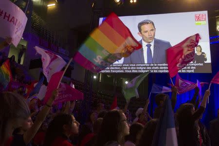 Supporters wave flags for Benoit Hamon, French Socialist party 2017 presidential candidate, who attends a campaign rally in Villeurbanne, near Lyon, France, April 11, 2017. REUTERS/Emmanuel Foudrot