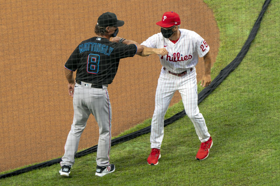 Miami Marlins manager Don Mattingly, left, gives an elbow-bump to Philadelphia Phillies manager Joe Girardi, right, prior to a baseball game, Friday, July 24, 2020, in Philadelphia. (AP Photo/Chris Szagola)