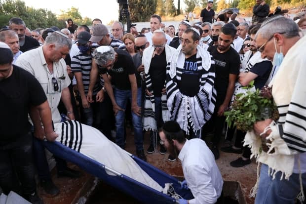 Family and friends in Moshav Hadid, Israel, mourn during the funeral Tuesday of Yigal Yehoshua, an Israeli man who died of wounds sustained during Arab-Jewish violence in the mixed city of Lod.