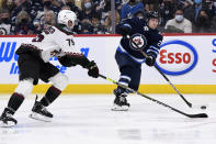 Winnipeg Jets' Nikolaj Ehlers (27) shoots past Arizona Coyotes' Kyle Caponbianco (75) during the second period of NHL hockey game action in Winnipeg, Manitoba, Monday, Nov. 29, 2021. (Fred Greenslade/The Canadian Press via AP)