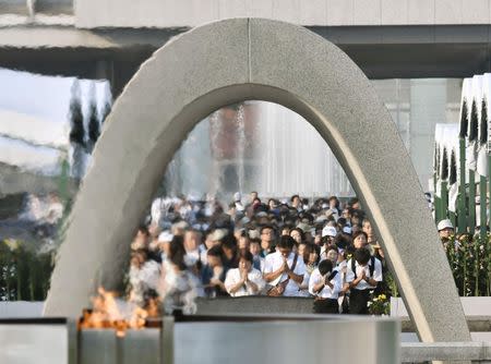 People pray in front of the cenotaph for the victims of the 1945 atomic bombing at Peace Memorial Park in Hiroshima, western Japan, in this photo taken by Kyodo August 6, 2016. Mandatory credit Kyodo/via REUTERS