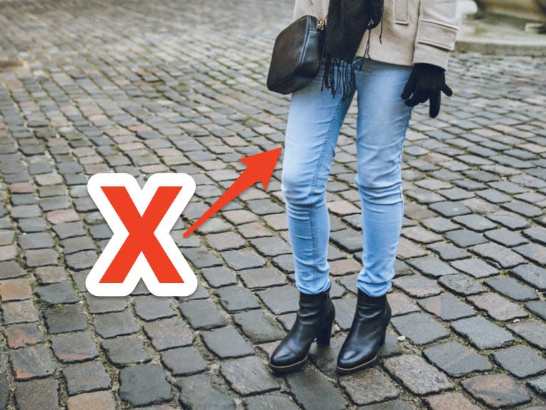 red x and arrow pointing at a pair of light wash skinny jeans
