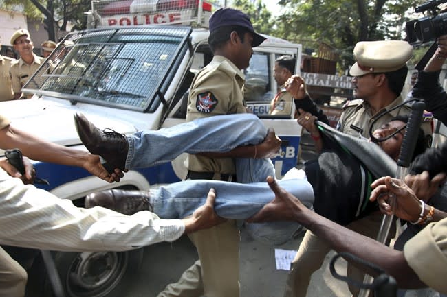 Indian policemen detain a left party activist during a protest against the alleged mistreatment of New York based Indian diplomat Devyani Khobragade, near the U.S Consulate in Hyderabad, India, Thursday, Dec. 19, 2013. The Indian diplomat said she faced repeated "handcuffing, stripping and cavity searches" following her arrest in New York City on visa fraud charges in a case that has infuriated the government in New Delhi. (AP Photo/Mahesh Kumar A.)