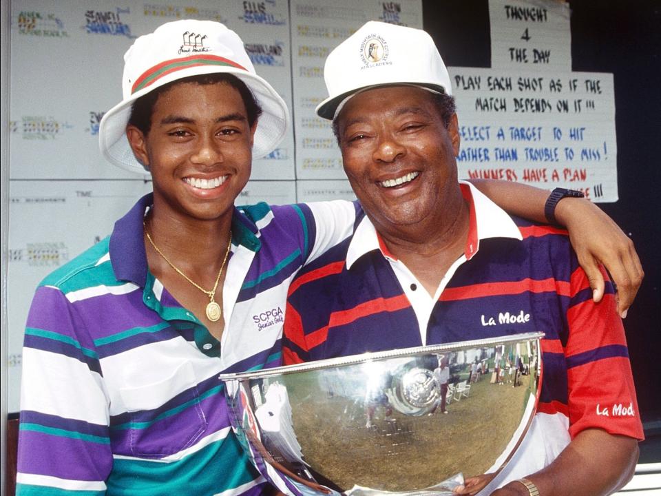 Tiger Woods, age 15 years, six months, and 28 days, and father Earl Woods, pose for a photo while celebrating Tiger's victory at the 1991 USGA Junior Amateur Championships on July 28, 1991 at the Bay Hill Club in Orlando, Florida