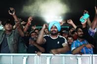 Laborers cheer at a fan festival at the Asian Town cricket stadium in Doha, Qatar, Friday, Nov. 25, 2022. Far from the luxury hotels and sprawling new stadiums emblematic of Doha during the World Cup, scores of soccer-mad South Asian workers poured into a converted cricket stadium in the city's desert outskirts to enjoy the tournament they helped create. (AP Photo/Jon Gambrell)