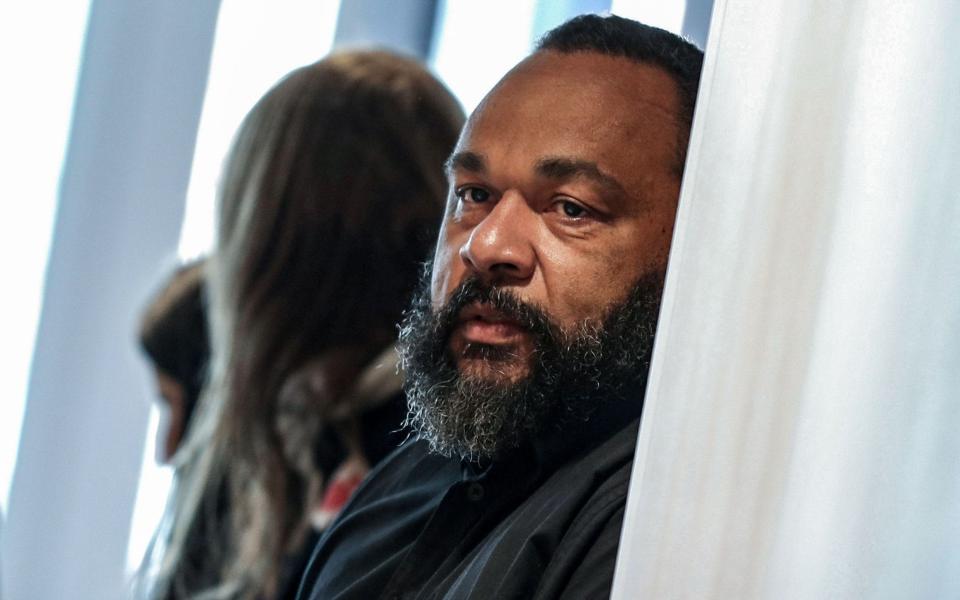 In this file photo taken on March 26, 2019 controversial French comic Dieudonne M'bala M'bala looks on as he arrives at the Paris courthouse - KENZO TRIBOUILLARD/AFP