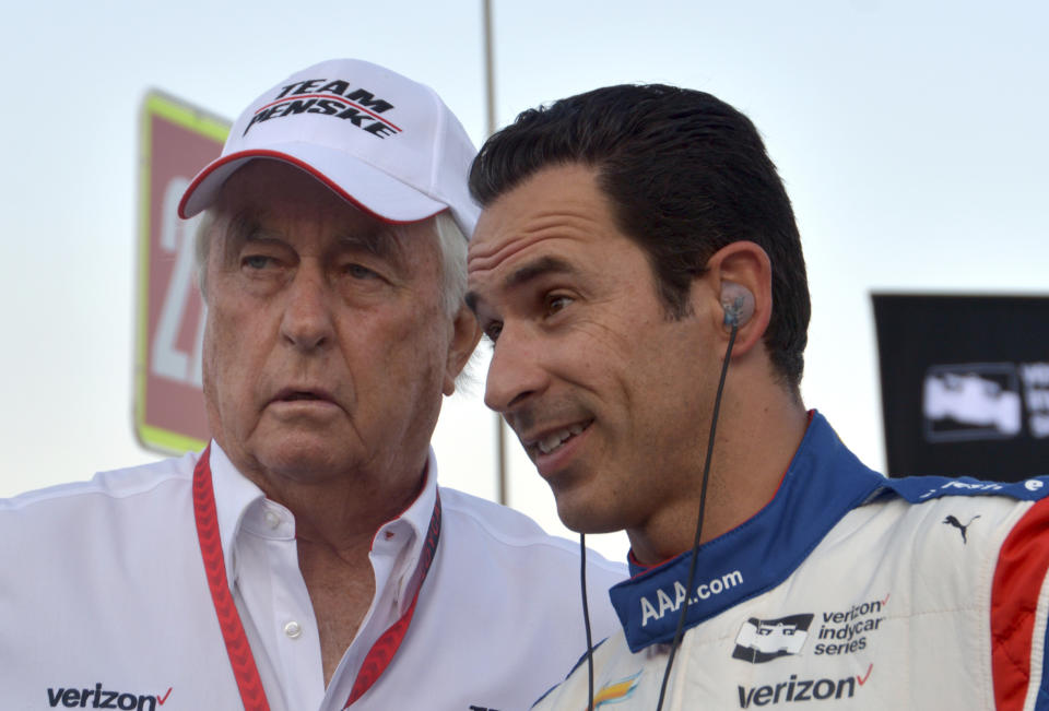 FILE – In this June 10, 2017, file photo, team owner Roger Penske, left, talks with driver Helio Castroneves, of Brazil, on pit road before an IndyCar auto race at Texas Motor Speedway in Fort Worth, Texas. Three-time Indianapolis 500 winner Helio Castroneves will move to Team Penske’s sports car program next season, bringing his 20-year full-time IndyCar career to an end. Castroneves will still drive for Penske at the Indianapolis 500. (AP Photo/Randy Holt, File)