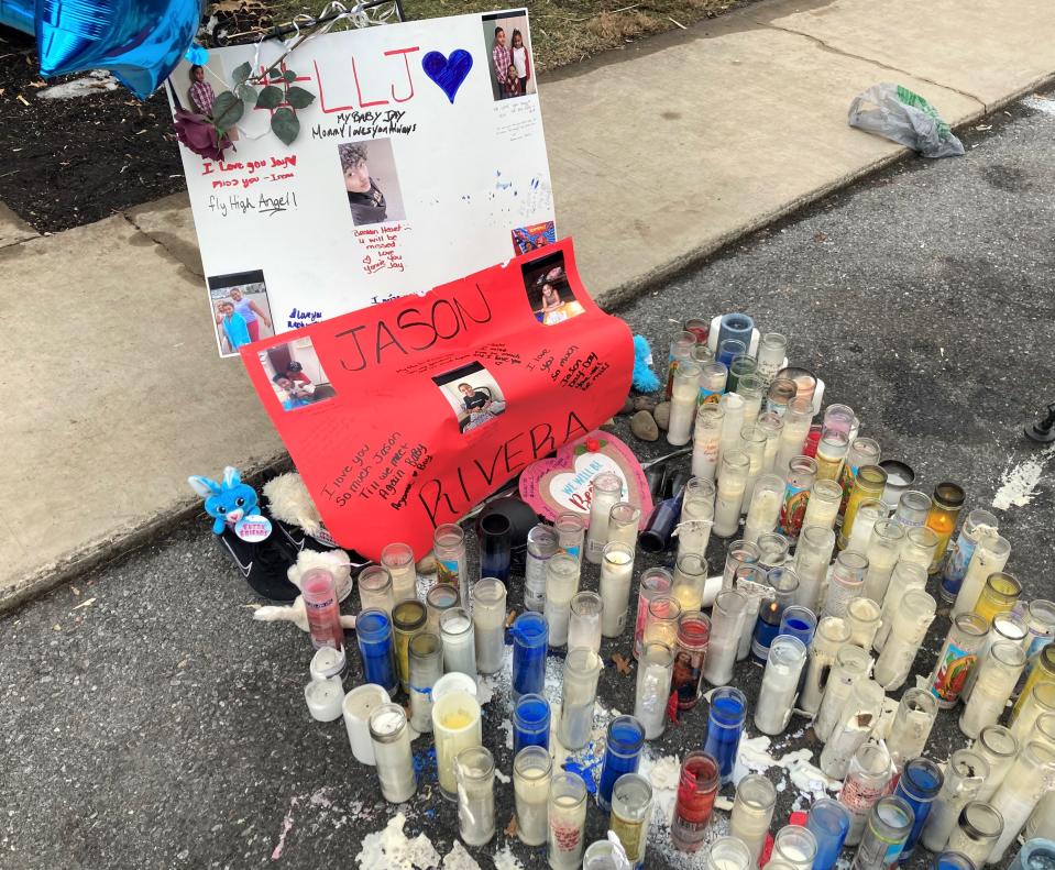Dozens of residents held a candlelight vigil for Jason Rivera at the site of the shooting Wednesday evening. The memorial still stood in the parking lot Thursday afternoon, with neighbors attempting to use tape and stones to keep it standing against the harsh winds.