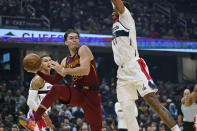 Cleveland Cavaliers' Cedi Osman (16) passes against Washington Wizards' Daniel Gafford (21) in the first half of an NBA basketball game, Wednesday, Nov. 10, 2021, in Cleveland. (AP Photo/Tony Dejak)