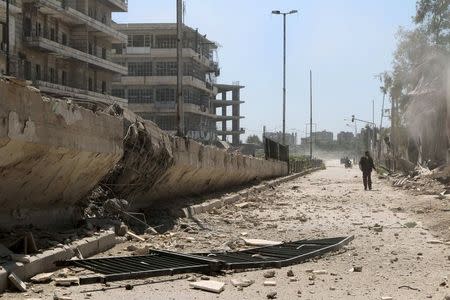 Residents inspect a damaged site after what activists said was a barrel bomb dropped by forces loyal to Syria's president Bashar Al-Assad in Al-Shaar nighbourhood of Aleppo, April 25, 2015. REUTERS/Mahmoud Hebbo