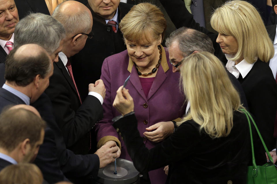 German Chancellor Angela Merkel casts her vote at the German federal parliament, Bundestag, in Berlin, Germany, Friday, Nov. 30, 2012. The German Parliament has given its overwhelming backing to a deal aimed at trimming Greece's debt load and keeping the country financially afloat. Lawmakers voted 473-100 on Friday to back the complex deal reached by European finance ministers earlier this week. The agreement paves the way for Greece to receive 44 billion euro (US $57 billion) in critical rescue loans, without which the country would face bankruptcy and a possible exit from the euro. (AP Photo/Michael Sohn)