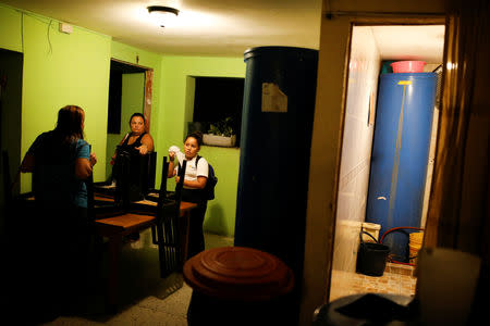 Yudith Contreras, a 49-year-old lawyer, talks with her sister Elba at her house in an apartment block in downtown Caracas, Venezuela, March 19, 2019. Contreras said her family recycles the water by using it to flush the toilet. In her kitchen and bathroom, she keeps containers of water, which she carries up the nine floors to her apartment, a few blocks from the presidential Miraflores Palace. "You have to save water because we don't know how long this situation will go on for," she said. REUTERS/Carlos Garcia Rawlins