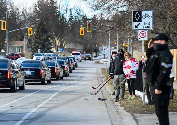 People gathered along the sidewalk to pay their respects as the funeral procession for Walter Gretzky passed by in Brantford, Ont., on Saturday afternoon.