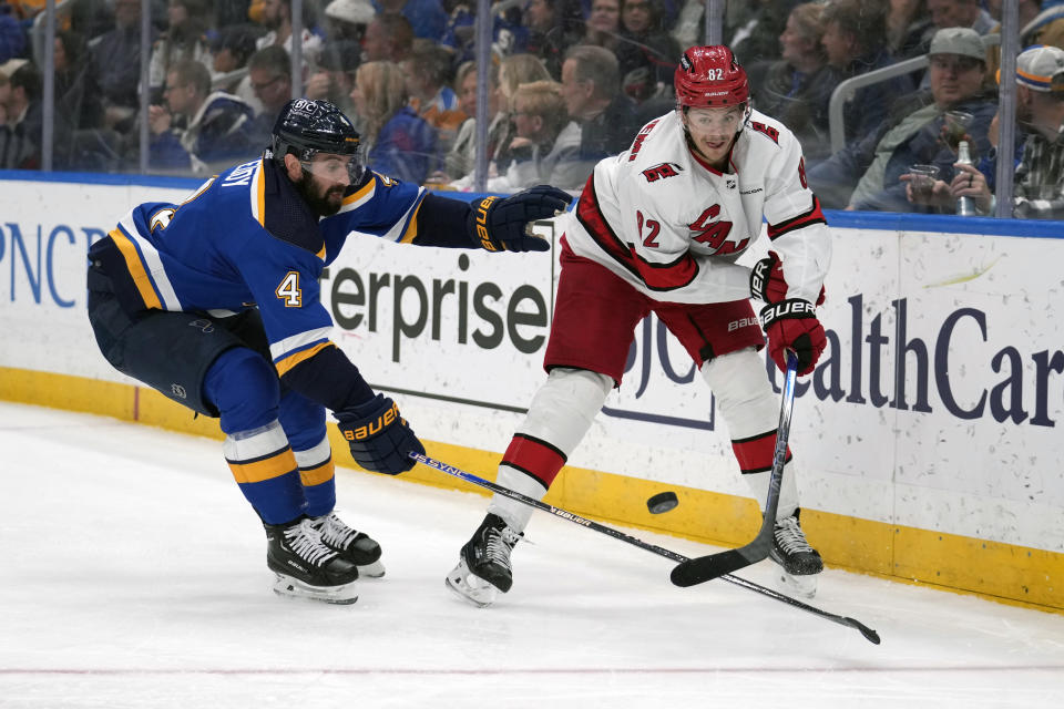 Carolina Hurricanes' Jesperi Kotkaniemi (82) clears the puck around St. Louis Blues' Nick Leddy (4) during the third period of an NHL hockey game Friday, April 12, 2024, in St. Louis. (AP Photo/Jeff Roberson)