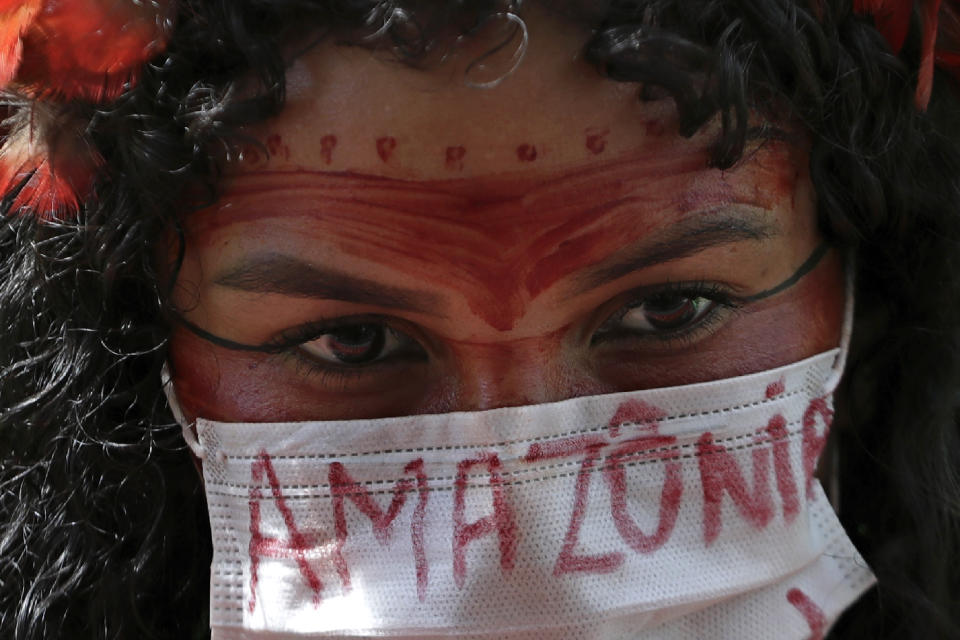 FILE - An Indigenous woman wears a protective face mask as a precaution against COVID-19 during a protest against Brazilian President Jair Bolsonaro's proposals to allow mining on Indigenous lands, at the Esplanade of Ministries in Brasilia, Brazil, April 20, 2021. Bolsonaro’s administration introduced legislation that would open up Indigenous territories to mining — something federal prosecutors have called unconstitutional and activists warn would wreak vast social and environmental damages. (AP Photo/Eraldo Peres, File)