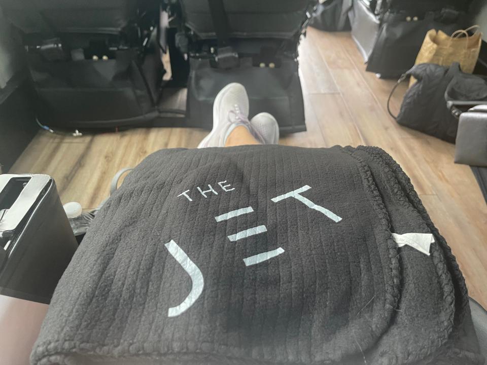 A view from the author's seat on the Jet Bus, where she has a large blanket on her lap that has "The Jet" written on it.