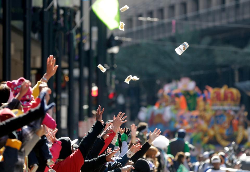 People reach for beads and trinkets during the Krewe of Rex parade on Mardi Gras in New Orleans, Tuesday, Feb. 17, 2015. Revelers in glitzy costumes filled the streets of New Orleans for the annual fat Tuesday bash, opening a day of partying and parades.