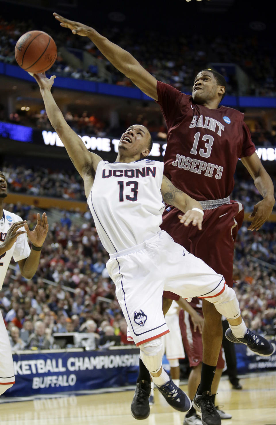 FILe - In this March 20, 2014 file photo, Connecticut's Shabazz Napier (13) drives past Saint Joseph's Ronald Roberts, Jr. (13) during the second half of a second-round game in the NCAA college basketball tournament in Buffalo, N.Y. Napier was selected to The Associated Press All-America team, released Monday, March 31, 2014. (AP Photo/Nick LoVerde, File)