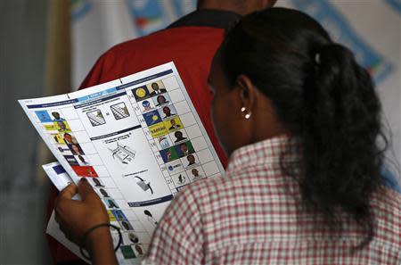 An electorate looks at the ballot sheet before casting her vote at a polling centre in the capital Antananarivo, December 20, 2013. REUTERS/Thomas Mukoya