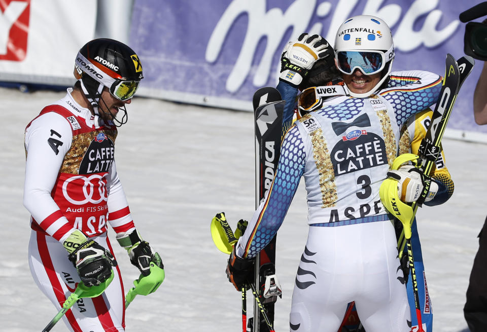 Sweden's Andre Myhrer, right, hugs Germany's Felix Neureuther as Austria's Marcel Hirscher, left, skis off after the second run of a men's World Cup slalom ski race Sunday, March 19, 2017, in Aspen, Colo. (AP Photo/Brennan Linsley)