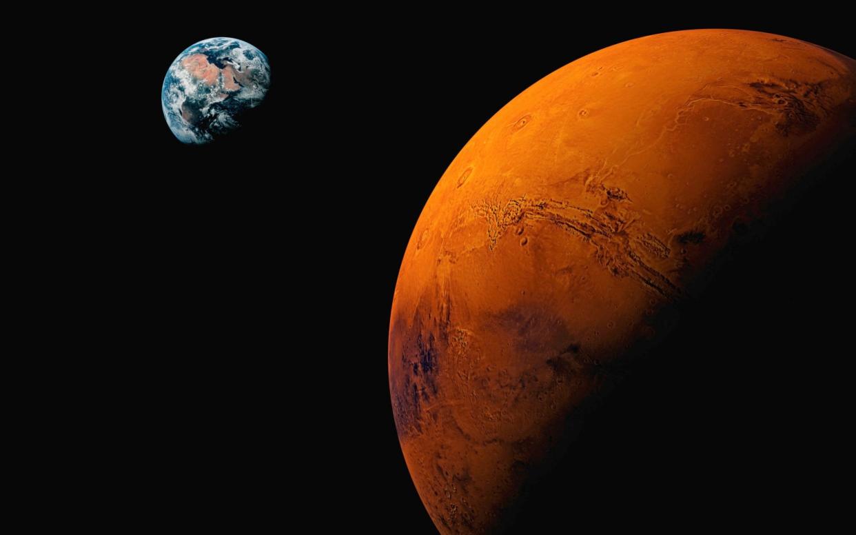 Planet Mars, with Earth visible in backgroun - Getty Images